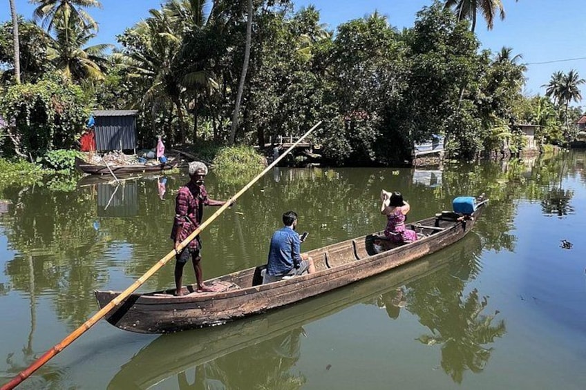 A traditional wooden boat on a calm river with people rowing. 3