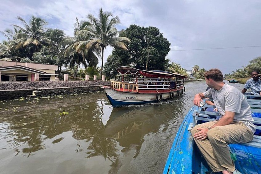 A river with a boat named ST. JUDE, a person sitting on the boat, and a building on the riverbank. 4