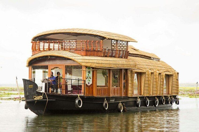 A houseboat with a wooden exterior and a curved roof, floating on water. 2
