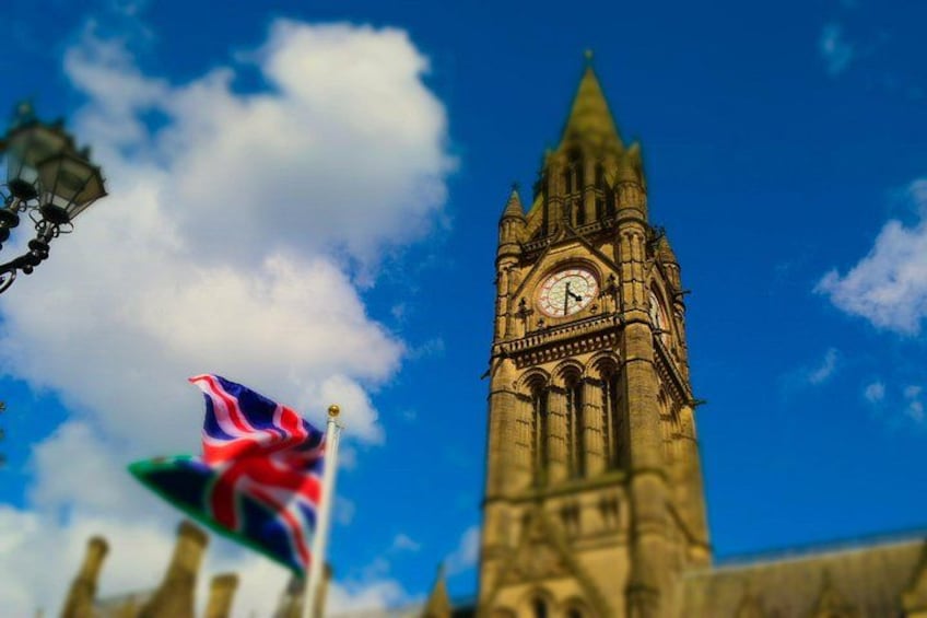 A clock tower with a flag in front. 2
