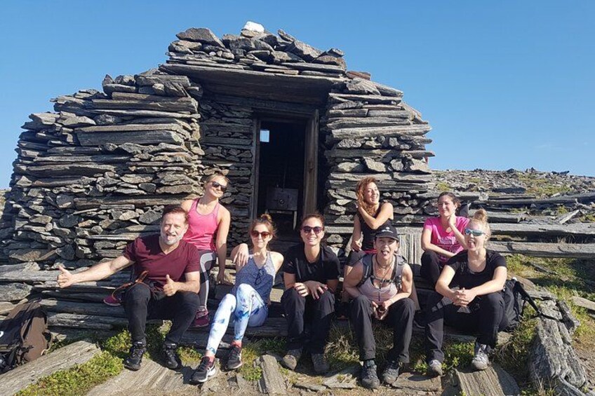 A group of people sitting in front of a stone structure. 3