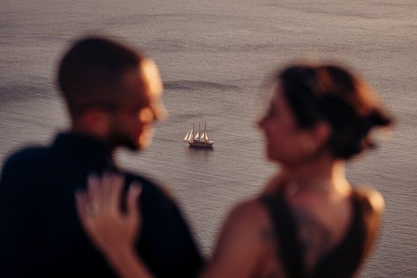 Een stel staat bij het water, met een zeilboot in de verte. 4