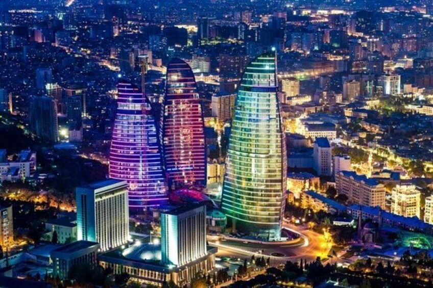 A cityscape at night with illuminated skyscrapers and a highway. 1