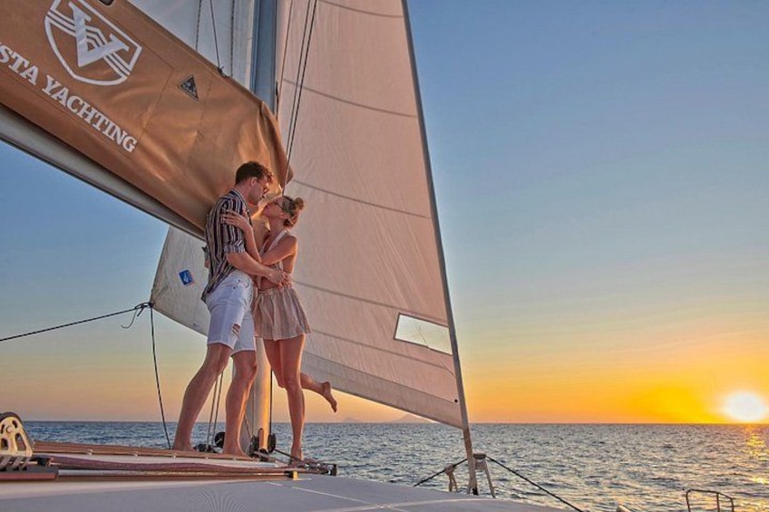 Een koppel op een zeilboot, met een zonsondergang op de achtergrond. 1