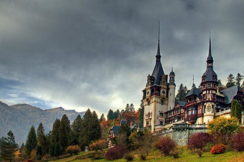 A castle with multiple towers, surrounded by trees and mountains. 5