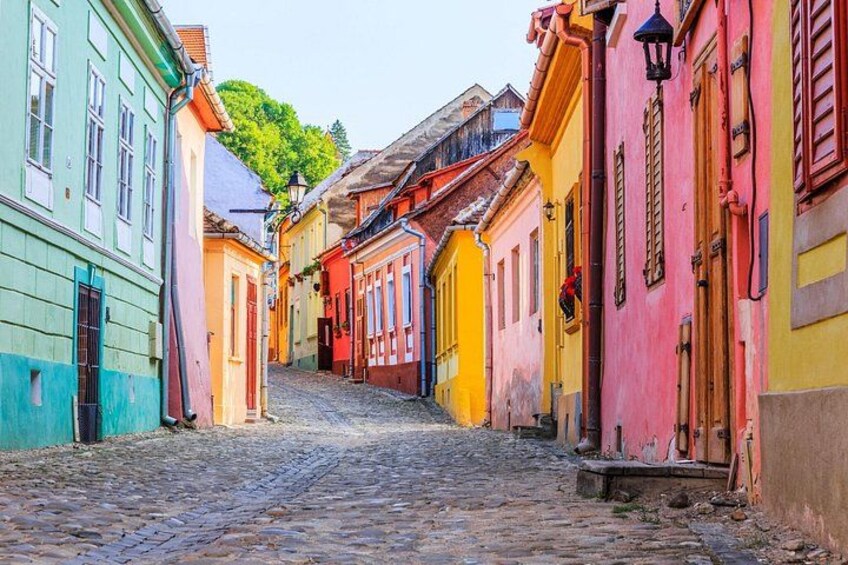 Una calle empedrada flanqueada por edificios coloridos. 4