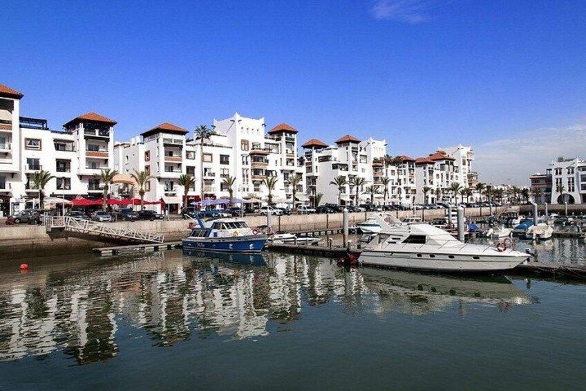 Un puerto deportivo con barcos, un paseo marítimo y edificios residenciales. 2