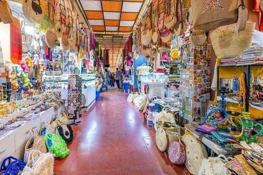 A market with various stalls selling bags and accessories. 5