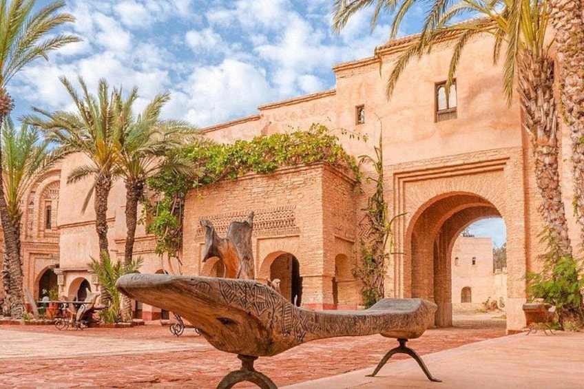 A courtyard with a fountain, palm trees, and a building with arches. 3