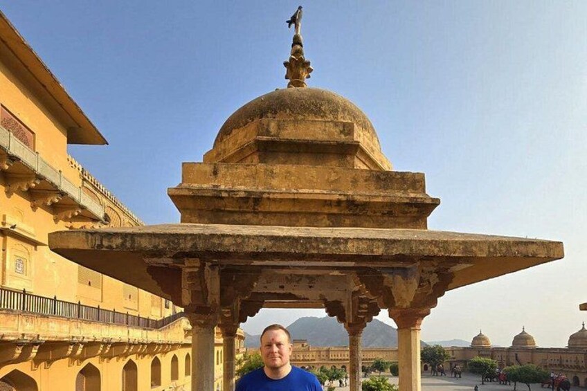 A historical building with a dome and a statue on top, surrounded by other structures. 4