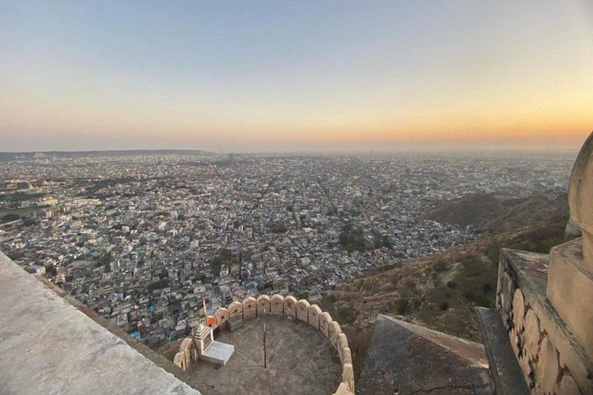 A panoramic view of a city from a high vantage point, including a circular stone structure and a distant horizon. 2