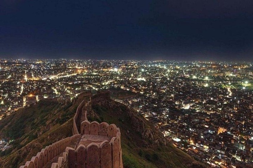 A cityscape at night with a prominent historical fort in the foreground. 3