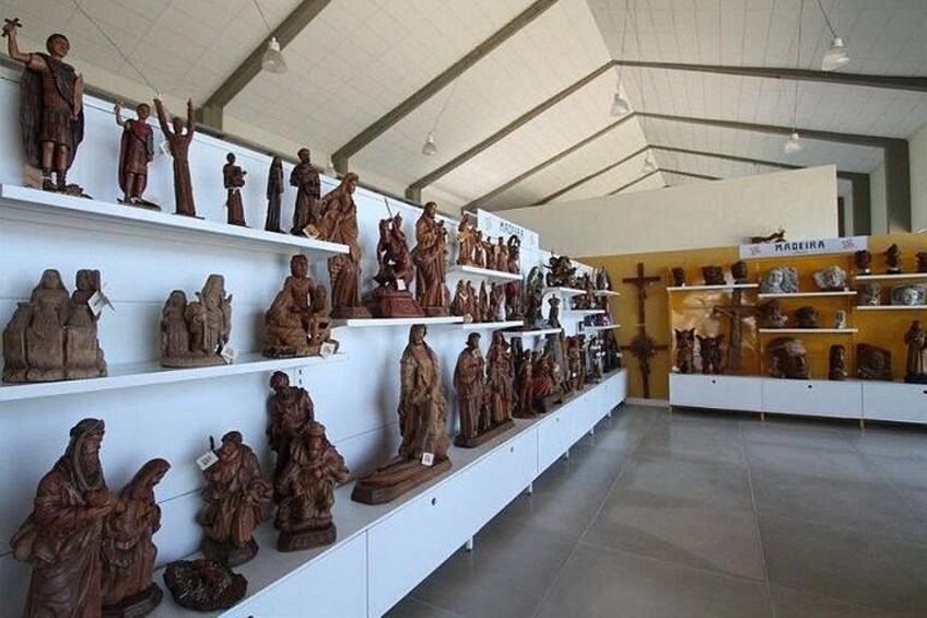 Ein Museuminneres mit hölzernen Skulpturen auf Regalen. 2