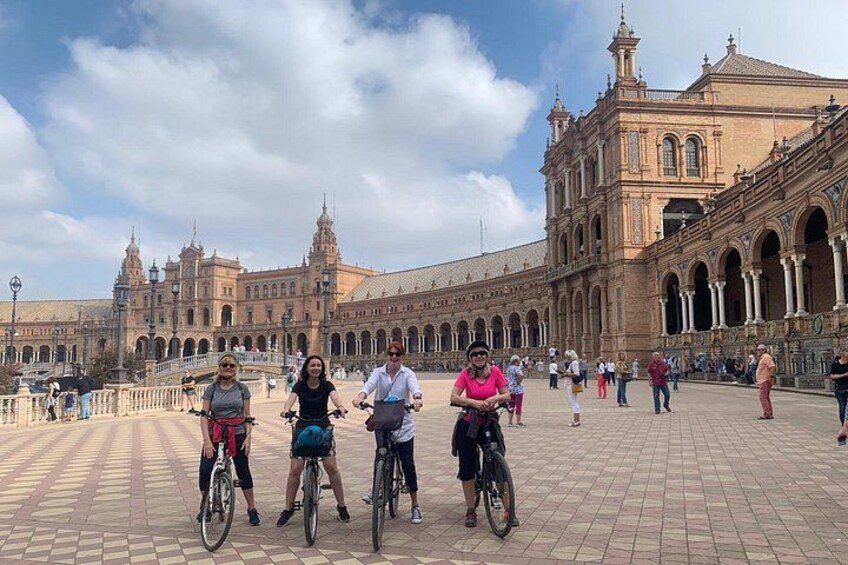 Un grupo de personas en bicicleta frente a un edificio histórico grande con arcos y columnas. 2