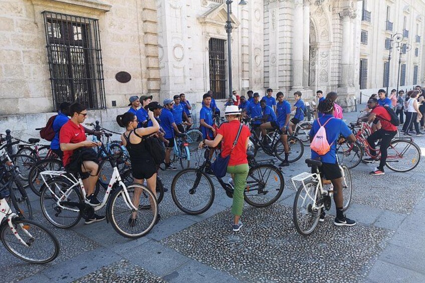 Un grupo de personas reunidas en bicicletas frente a un edificio histórico. 3
