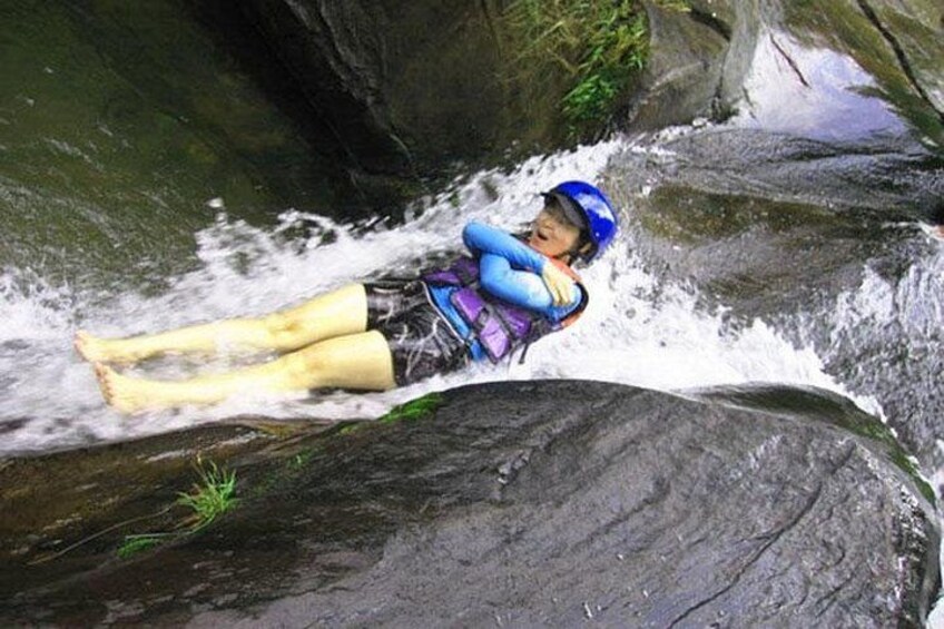 Una persona in tuta blu e casco che si fa strada tra rapide di un fiume. 2