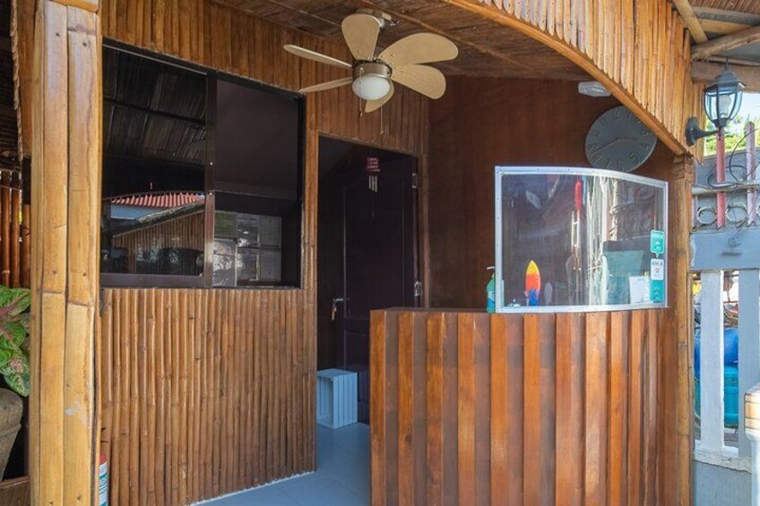 A wooden structure with a sloped roof, a fan, and a clock. 5