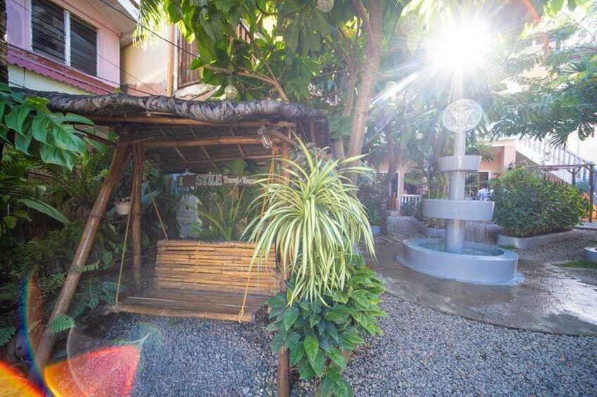 A garden with a wooden structure, a hanging plant, and a water feature. 2