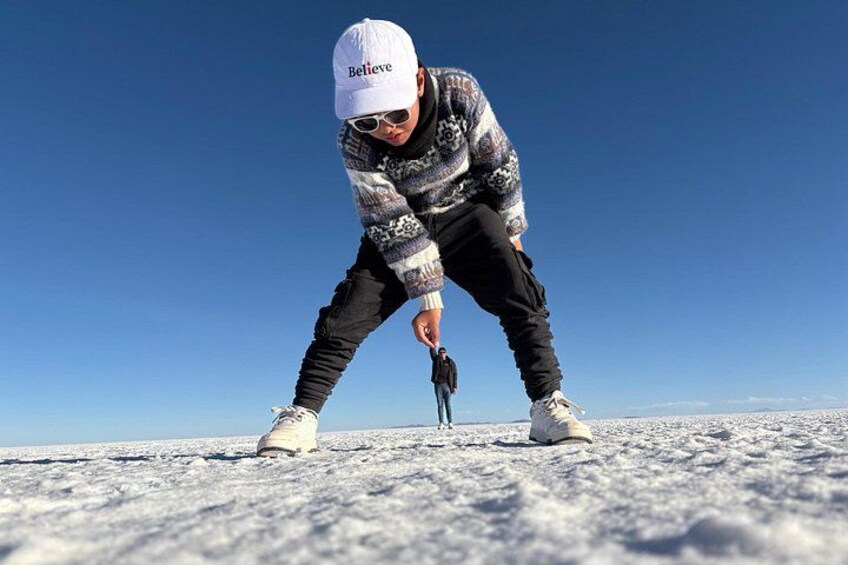 Una persona con una chaqueta estampada y gorra blanca sobre nieve. 5