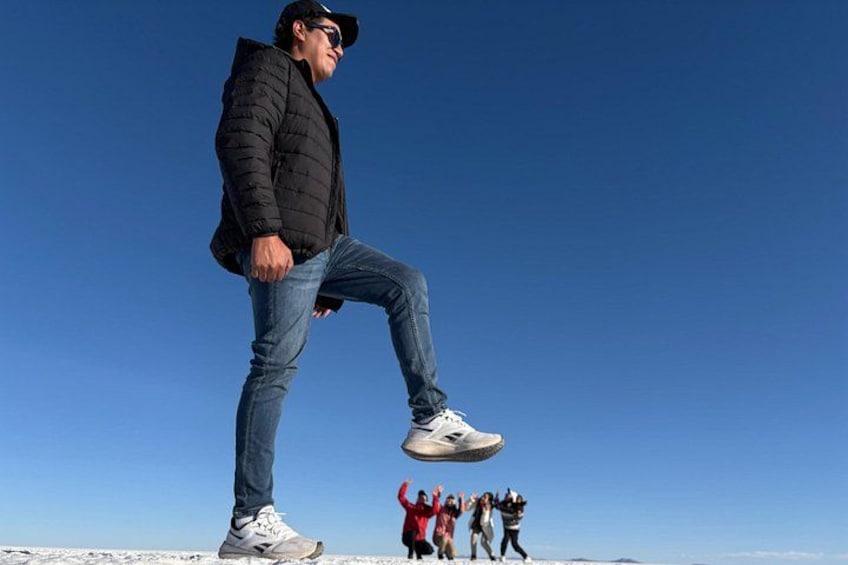 Una persona parada sobre una superficie nevada bajo un cielo azul despejado. 4