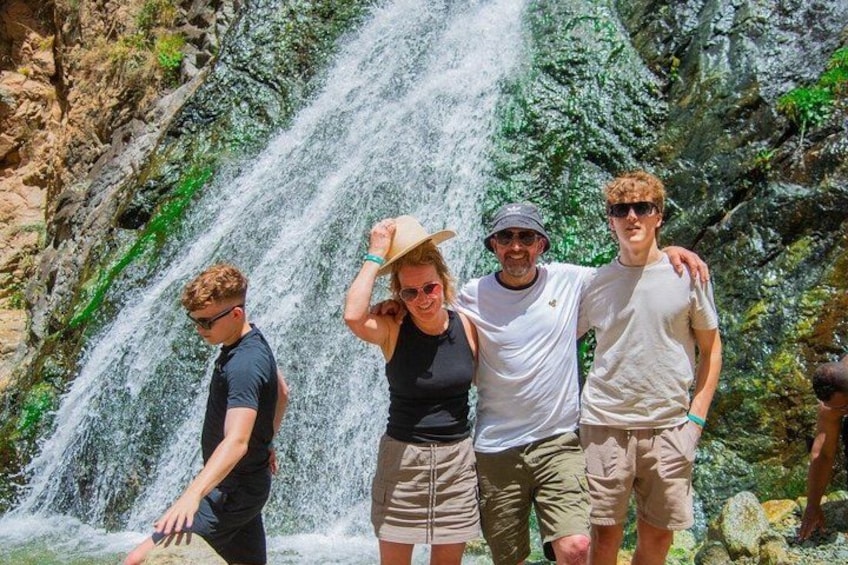 A waterfall with people standing in front of it. 4