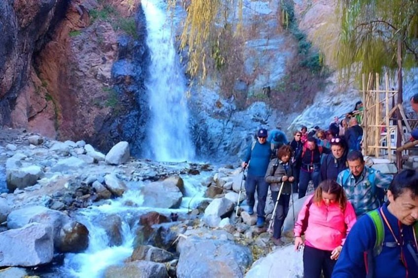 A waterfall, rocky terrain, and a group of hikers. 3
