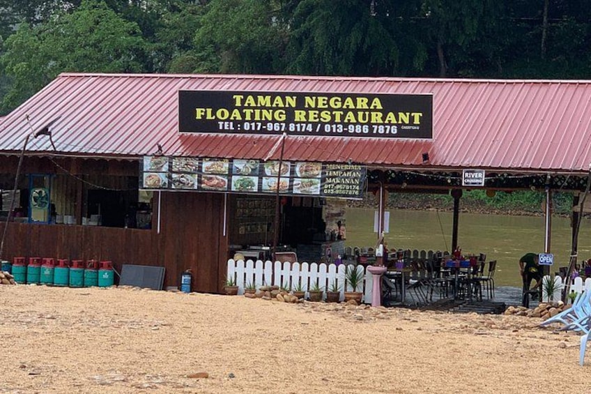 Un ristorante galleggiante chiamato Taman Negara con tetto rosso e insegna. 2