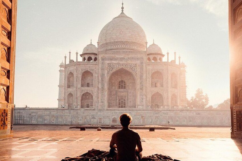 A person sitting in front of the Taj Mahal. 3
