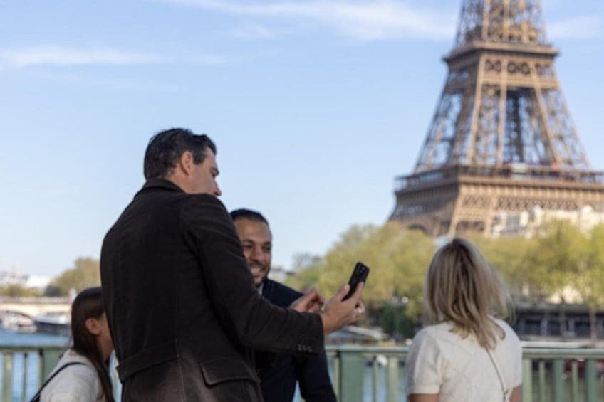 A group of people standing near the Eiffel Tower. 2