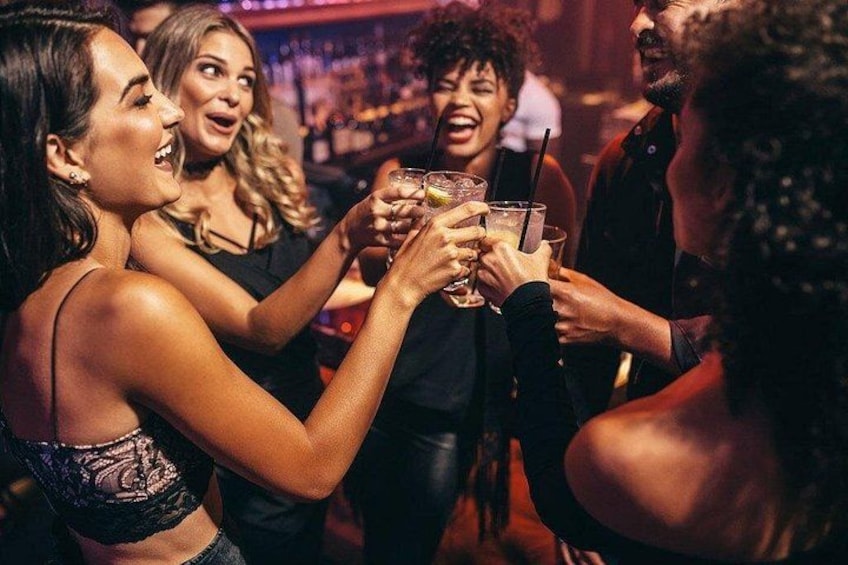 Un groupe de personnes trinquant avec des boissons dans un endroit intérieur à la lumière tamisée. 5