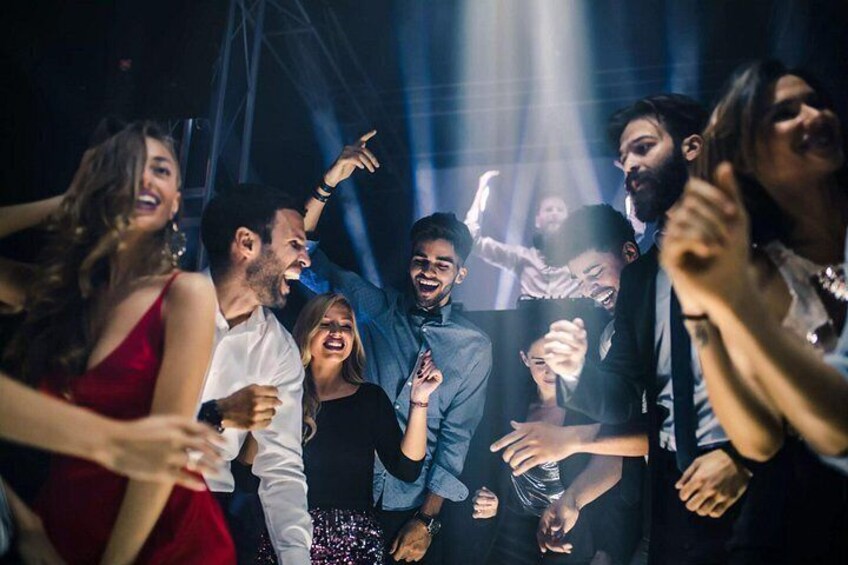 En grupp människor som dansar på en nattklubb. 3