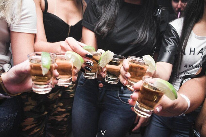 Un groupe de personnes tenant des verres contenant une boisson et des quartiers de citron vert. 3
