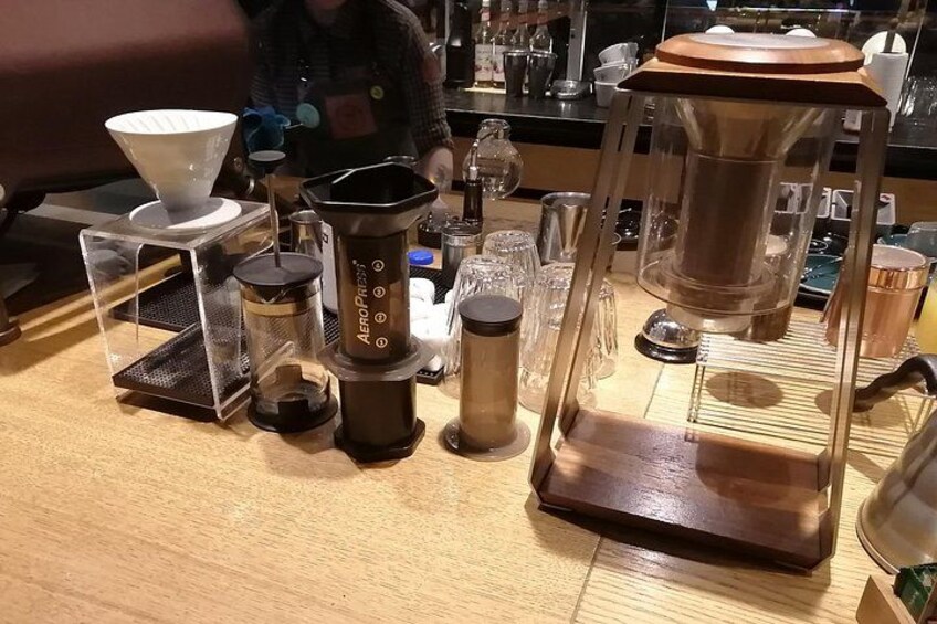 A coffee shop counter with various coffee brewing equipment. 5