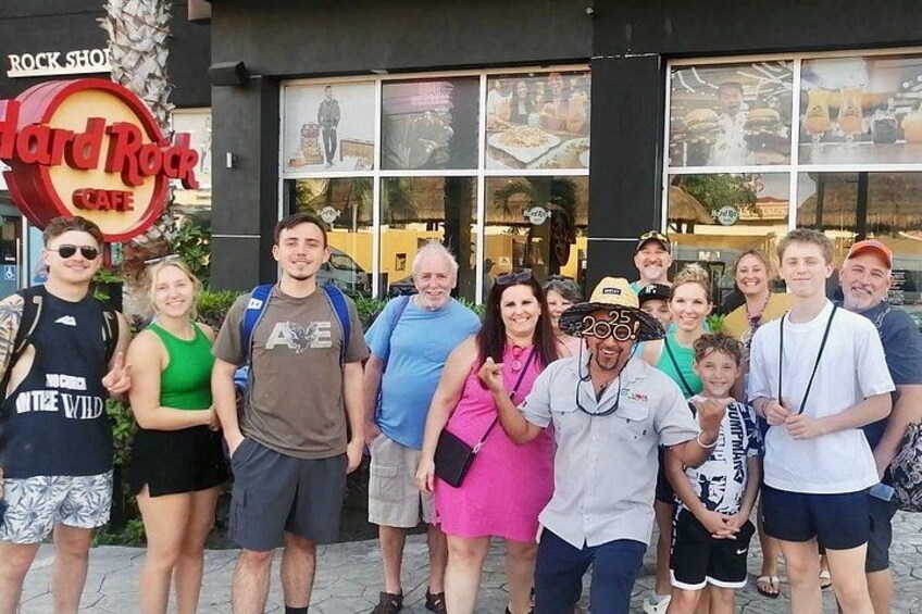 A group of people standing in front of a Hard Rock Cafe. 2