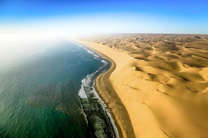 A coastal landscape with a sandy beach and dunes. 5