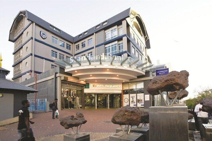 A modern building with a curved entrance and a sign that reads "town square." 1