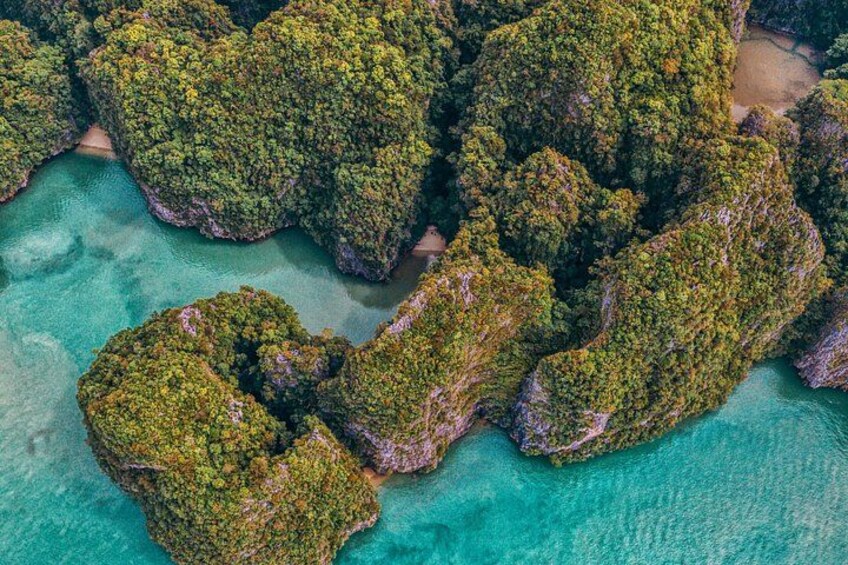 Een luchtbeeld van een groep weelderige groene eilanden, omgeven door turquoise water. 3