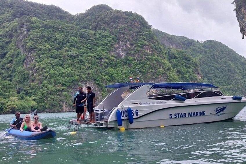 A boat named '5 Star Marine' with people on a small inflatable raft nearby. 1