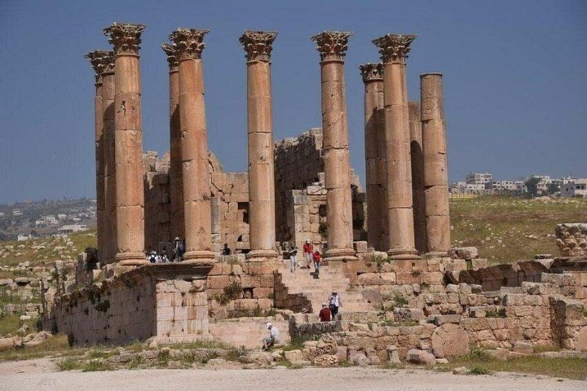 Des ruines antiques, avec des colonnes, et quelques personnes qui se promènent. 1