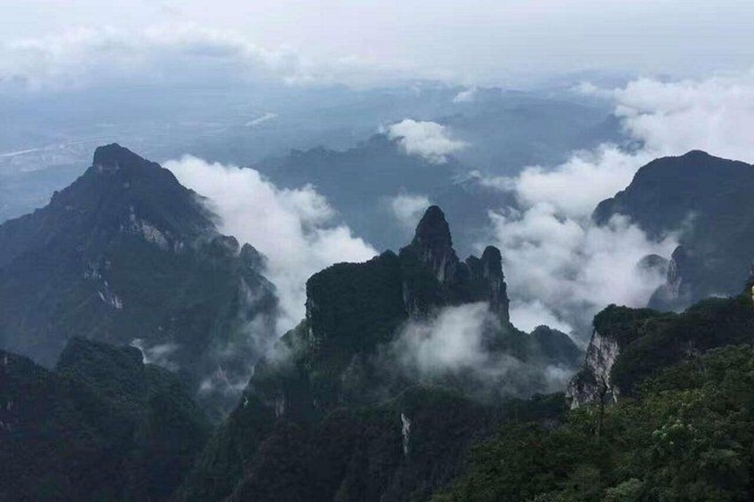 Un paisaje montañoso con cumbres destacadas y un valle cubierto de nubes. 2