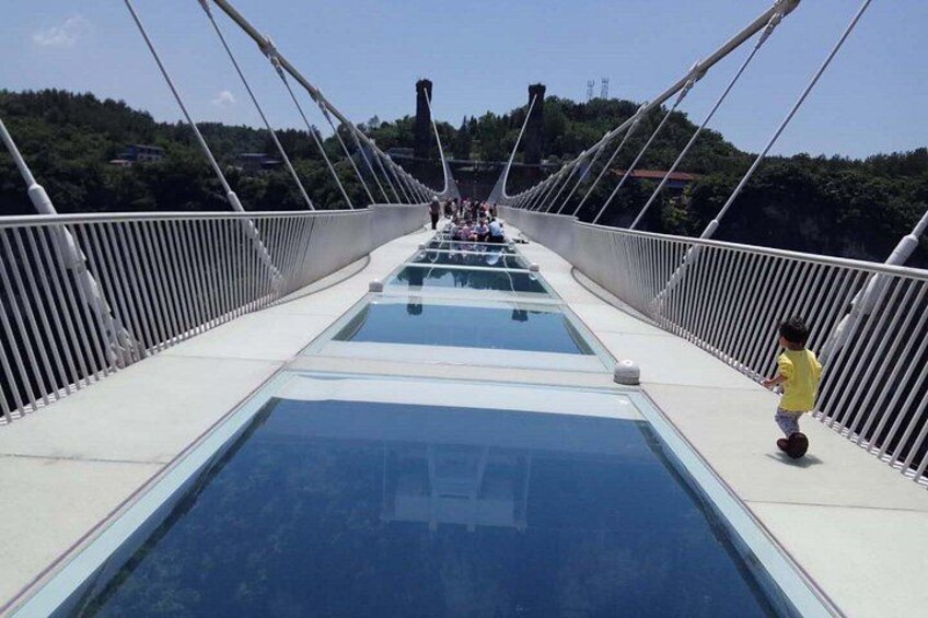 Een voetgangersbrug met glazen panelen en witte hekwerken. 2