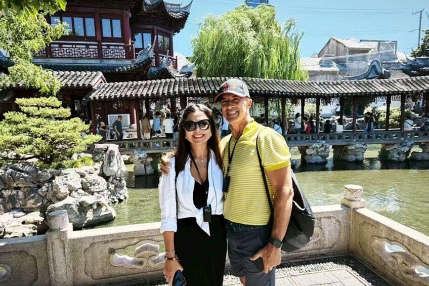 A traditional Chinese garden with a stone bridge, pagoda, and a pond. 2