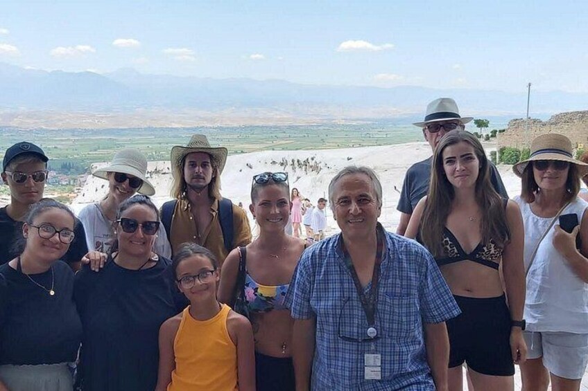Un groupe de personnes se trouve sur une plage, avec un paysage montagneux en arrière-plan. 5