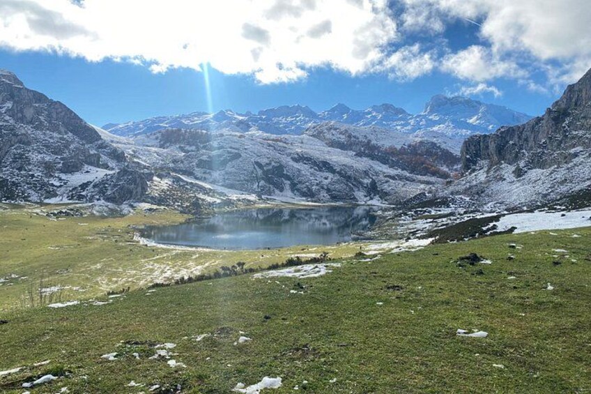 A mountainous landscape with a lake, snow-covered peaks, and a clear sky. 5