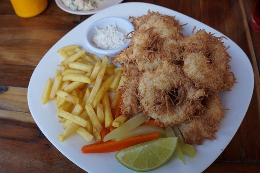 A plate of food with fries, a lime wedge, carrot sticks, and a small bowl of sauce. 4