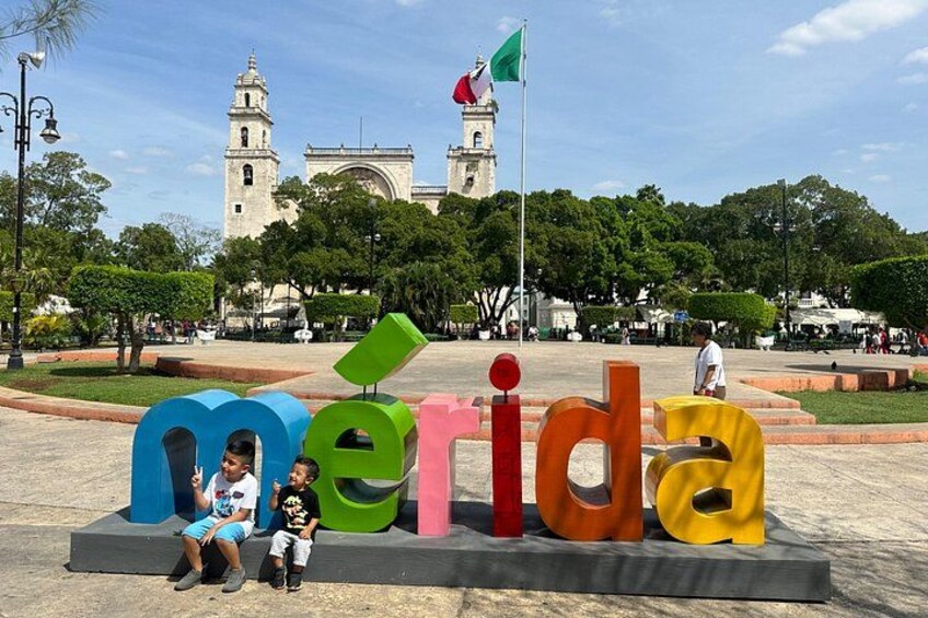 A colorful sign with the word 'merida' and a flag in the background. 2