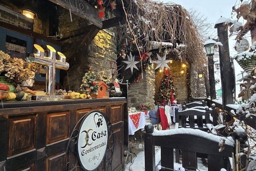 A rustic outdoor bar with a Christmas tree and decorations. 3
