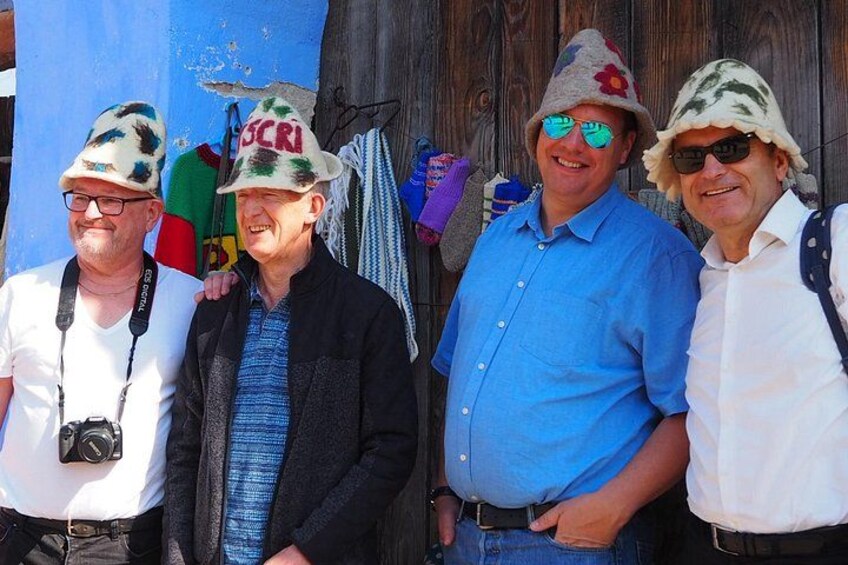 Four people standing outdoors, wearing hats and casual clothing. 4