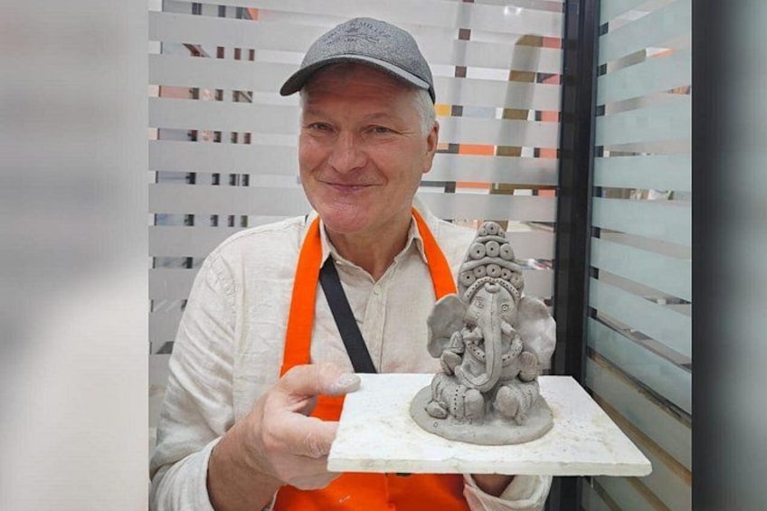 Una persona sosteniendo una escultura de una divinidad. 5