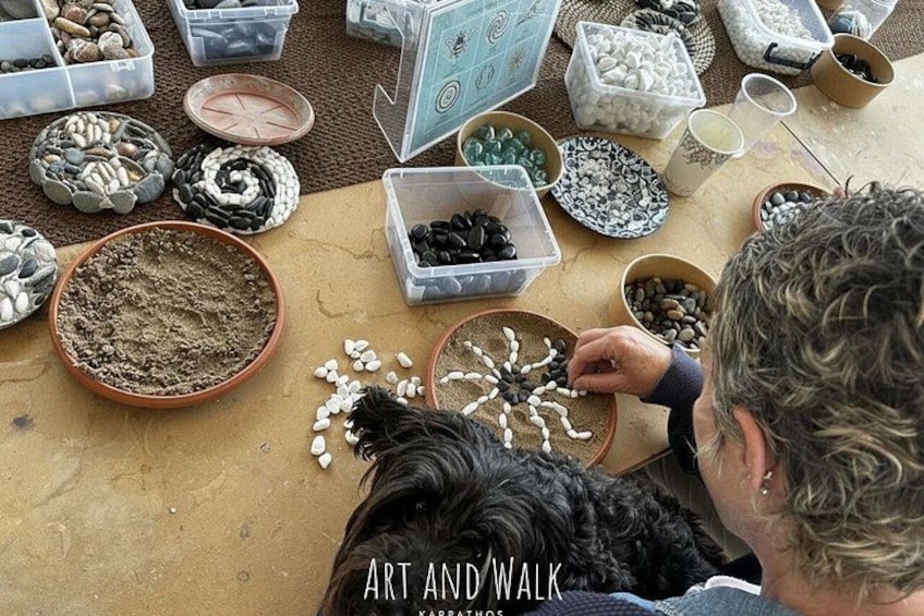 A person arranging stones on a table with various containers of stones. 3